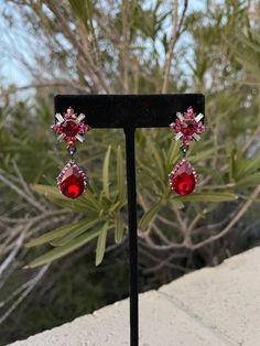 "These fun and stylish red crystal rhinestone earrings are a great statement piece! Pageant, prom, or evening!  Size of earrings: .75\" Wide and 1.5\" Long.  color available: Red and AB crystals Style: pierced More colors available upon request, just message us! Need a matching bracelet? https://www.etsy.com/listing/569699193/red-rhinestone-bracelet-red-stretch?ref=shop_home_active_44 https://www.etsy.com/listing/538148439/red-crystal-bracelet-large-crystal?ref=shop_home_active_2 https://www.etsy.com/listing/573498244/red-rhinestone-bracelet-wide-red?ref=shop_home_active_23 Looking for the perfect pair of earrings for a special occasion. We specialize in custom work in fashion jewelry, pearls, and natural stones! Please feel free to browse through our other listings, and if you can't find Bridal Jewellry, Pageant Earrings, Fun Ornaments, Prom Earrings, Red Prom, Large Crystal, Matching Bracelet, Earrings Red, Red Earrings