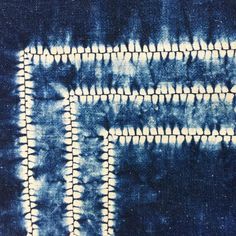 a blue and white tie - dye background with squares in the middle, on top of another pattern