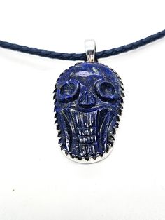 Lapis Lazuli hand carved skull pendant sterling silver custom corded chain. Good vintage condition with little signs of normal wear. Custom braided corded chain with sterling silver capped clasp. Clasp opens with push button on the side. Pendant is set in sterling silver with large saw tooth bezel. Pendant stamped on the back 925. Acid tests positive for sterling silver. Necklace measures 18 inches long. Pendant measures 2 inches long and 1 inch wide. Adjustable Carved Sterling Silver Jewelry, Carved Skull, Saw Tooth, Silver Caps, Black Fire, Skull Carving, Skull Pendant, Bezel Pendant, Long Pendant