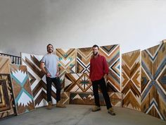 two men standing in front of art pieces