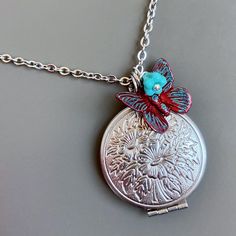 Red Butterfly Locket Necklace -  Stainless Steel  Locket with a Floral Pattern.  The locket is accented with a Dark Red Patina'd Butterfly with Turquoise Highlights, and small Turquoise Czech Glass Flower The locket is approximately 27mm (a little larger than an US quarter).    It is a working locket that could be used for a keepsake.   Stainless Steel Chain For other locket designs:  http://www.etsy.com/shop/mcstoneworks/search?search_query=locket&search_submit=&search_type=user_shop_ttt_id_5402200&shopname=mcstoneworks Red Locket Jewelry For Gift, Red Locket Jewelry As A Gift, Personalized Red Jewelry For Keepsake, Bohemian Adjustable Jewelry For Keepsake, Red Medallion Necklace For Gift, Adjustable Bohemian Jewelry Keepsake, Personalized Vintage Red Jewelry, Personalized Red Keepsake Jewelry, Handmade Adjustable Locket Necklace Gift