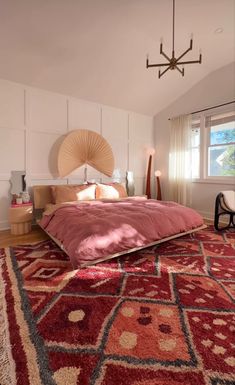 a bedroom with a large rug on the floor and a chandelier hanging from the ceiling