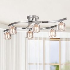 a chrome finish ceiling light with clear glass cubes hanging from it's center