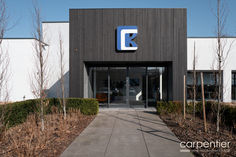 the entrance to a building with trees and bushes