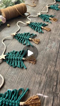 several green and gold tassels on a wooden table next to twine spools