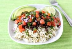 a white plate topped with rice, beans and avocado