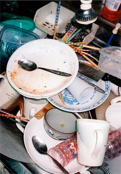 dirty dishes and utensils are piled on top of each other