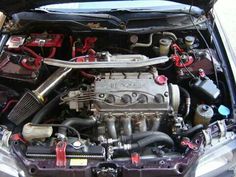 the engine compartment of a car with its hood open and it's hoses running