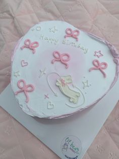 a birthday cake is decorated with pink bows and an infant's name on it