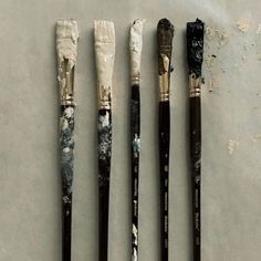 four different types of paintbrushes sitting on top of a table next to each other