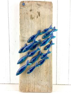 five blue glass fish on a wooden board