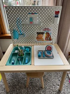 a wooden table with two trays on top of it and toys in the middle