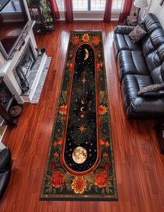 a living room with black leather couches and a rug on the floor that has an image of the moon and stars