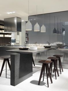 a modern kitchen with an island and bar stools