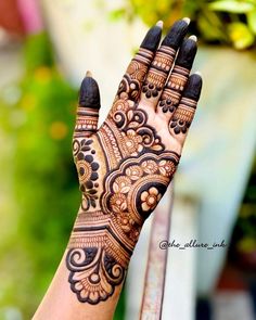 a woman's hand with hennap on it and flowers in the background