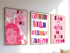 three pink posters are hanging on the wall above a couch in a room with white walls