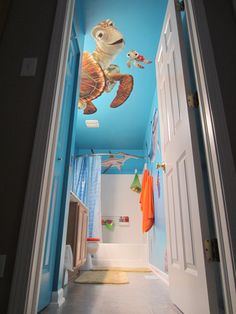 an open door leading to a bathroom with a turtle mural on the ceiling and blue walls