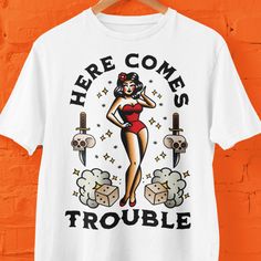 For those who like tattoos or for friends who do this traditional old-school design is a must have. Here Comes Trouble a Sailor Jerry vibe is printed on Comfort Colors t shirts which are my personal favorites. This makes a wonderful gift for Christmas, birthdays, as a stocking stuffer or for a Secret Santa gift.  Comfort Colors introduces its garment-dyed t-shirt; a fully customizable tee made 100% with ring-spun cotton. The soft-washed, garment-dyed fabric brings extra coziness to your wardrobe Trouble Tattoo, Tattoo Shirt Design, Frank Turner, Here Comes Trouble, Tattoo T Shirt, Like Tattoos, Tattoo Shirt, Tattoo Shirts, Tattoo T Shirts