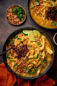 two black bowls filled with food on top of a table