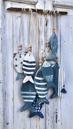 three wooden fish hanging on the side of a white door