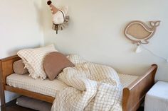 a bed with pillows and blankets on top of it in a bedroom next to a wall clock