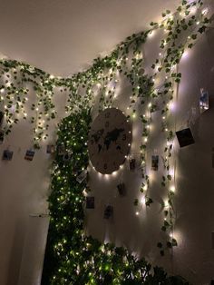 there is a clock on the wall covered with vines and lights that are hanging from the ceiling