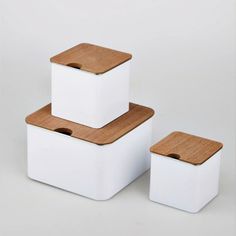 three square white containers with wooden lids on each one and two smaller ones in the middle