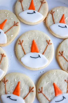 decorated cookies with frosting and orange hats on them