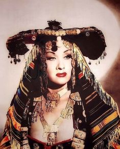 a woman wearing an elaborate head piece and jewelry