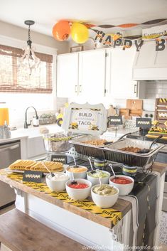 an image of a baby shower party with food on the kitchen counter and balloons in the background