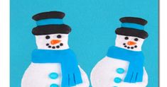 two snowmen with hats and scarves made out of icing on a blue background