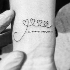 a small tattoo with hearts on the wrist