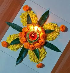 an arrangement of flowers with a lit candle in the center