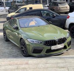 a green car parked next to other cars