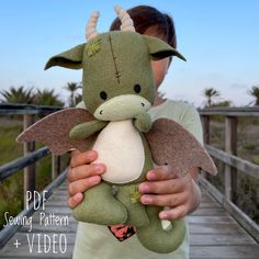 a person holding a stuffed animal on a wooden bridge with palm trees in the background