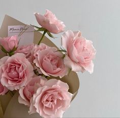 some pink flowers are in a vase with a note on it that says mom's day