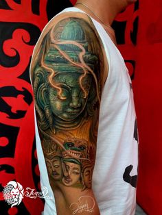 a man with a tattoo on his arm that has an image of a buddha head