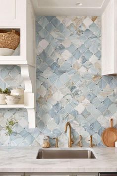 a kitchen with white cabinets and blue tile backsplash