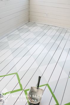 a bucket and paint roller sitting on the floor in a room with white painted walls