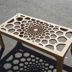 a small table with holes in the middle on concrete ground next to pavement and street