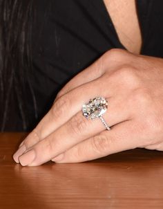 a woman's hand with a diamond ring on it