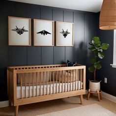 a baby's room with two framed pictures on the wall and a crib