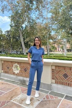 Female medical professional wearing the MOVEMENT by Butter-Soft Ceti Women's 1-Pocket V-Neck Tuck-In STRETCH Scrub Top and the Movement by Butter-Soft Women’s 7-Pocket Skinny Pintuck Scrub Pants Fall 2022, 4 Way Stretch Fabric, Scrub Tops