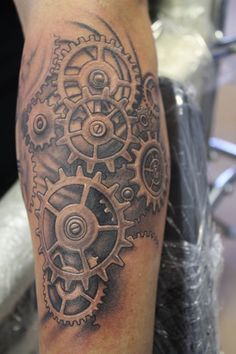 a man with a tattoo on his leg that has gears and cogs all over it