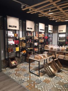 the inside of a book store with lots of books on shelves and wooden chairs in front of them