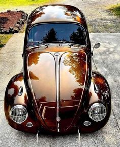 the front end of an antique car parked in a driveway