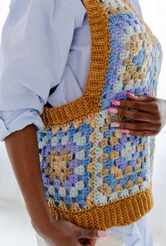 a woman is holding a crocheted bag in her hands