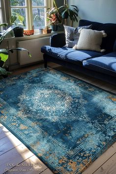 a living room with a blue couch and large rug on the floor in front of a window