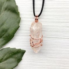 Natural Clear Quartz Necklace. Raw Clear Quartz crystal wrapped with 99.9% pure copper wire that is tarnish resistant. Comes on a black satin lobster clasp necklace. You get the exact pendant pictured.  Pictures are taken close up. Exact pendant measurement is 1.8 Inches H X 0.6 Inches W. This Clear Quartz is from Brazil. ✨ Pendant handcrafted during the Moon in Pisces. ✨ Items included with purchase- -Raw Clear Quartz copper pendant on a black lobster clasp necklace. -Drawstring pouch. -Handmad Adjustable Hand Wrapped Copper Crystal Necklaces, Adjustable Hand Wrapped Copper Crystal Necklace, Rose Gold Hand Wrapped Necklace Gift, Handmade Adjustable Rose Gold Crystal Necklaces, Rose Gold Copper Wire Necklace For Gift, Rose Gold Copper Wire Necklace Gift, Spiritual Adjustable Copper Crystal Necklaces, Adjustable Spiritual Copper Crystal Necklaces, Hand-wrapped Copper Wire Crystal Necklace For Gifts