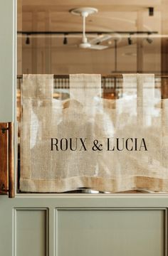 a burlocked sign on the front door of a restaurant that says roux & lucia